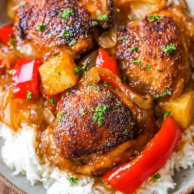 Slow Cooker Hawaiian Pineapple Chicken dish served with rice and garnished with green onions.