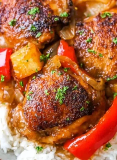 Slow Cooker Hawaiian Pineapple Chicken dish served with rice and garnished with green onions.