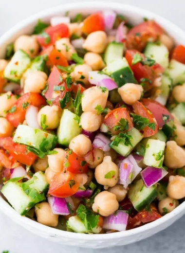 Colorful chickpea salad with fresh vegetables and herbs in a bowl