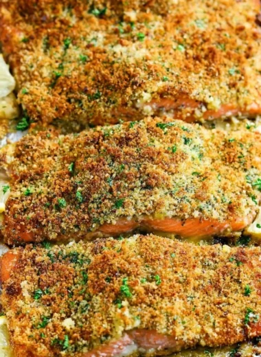Crispy Garlic Parmesan Salmon fillet garnished with herbs on a plate.