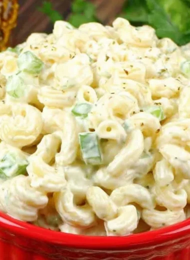Bowl of deli-style macaroni salad with colorful vegetables and creamy dressing