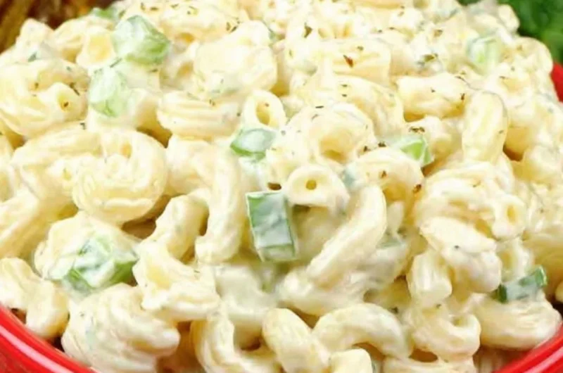 Bowl of deli-style macaroni salad with colorful vegetables and creamy dressing