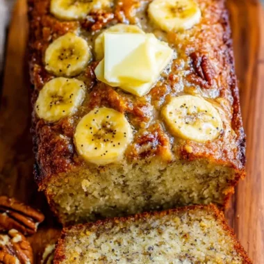 Loaf of freshly baked banana bread topped with sliced bananas