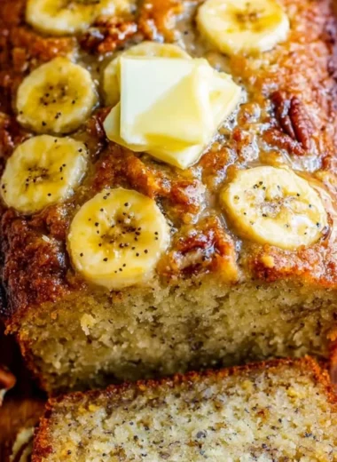 Loaf of freshly baked banana bread topped with sliced bananas