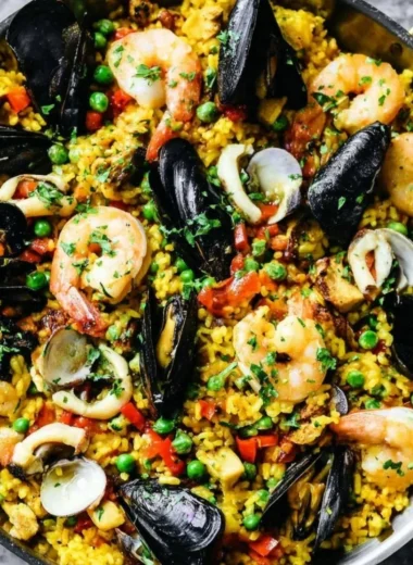 A vibrant plate of authentic paella with seafood, rice, and fresh vegetables.