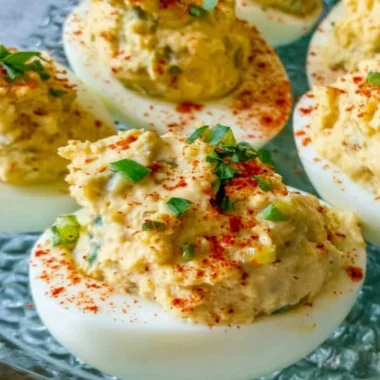 Cajun Deviled Eggs topped with spices and herbs on a serving platter