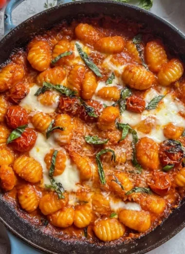 Creamy tomato gnocchi garnished with fresh basil and grated cheese.