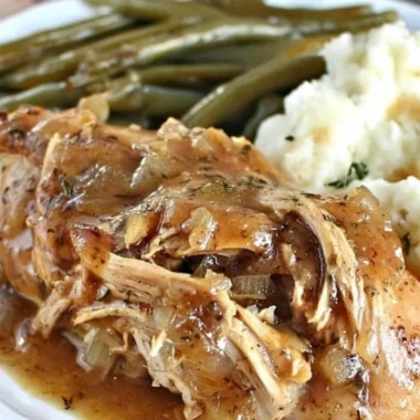 Delicious Crock Pot Mississippi Chicken served with sides on a rustic table