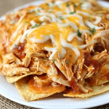 Crockpot Taco Chicken Nachos topped with cheese and jalapeños