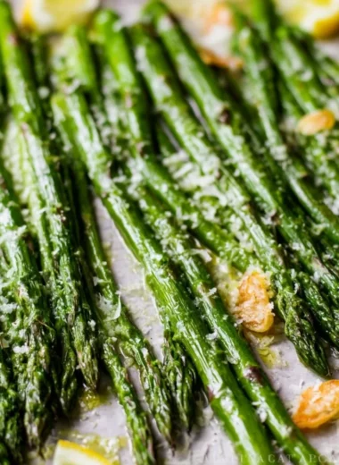 Oven-roasted garlic Parmesan asparagus on a plate with a sprinkle of cheese