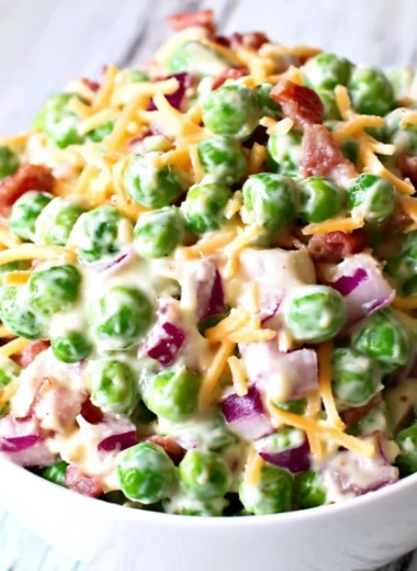 Delicious pea salad with red onions and cheese in a bowl.
