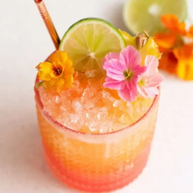 Vibrant Pineapple Mango Rum Punch in a decorative glass with tropical fruits.