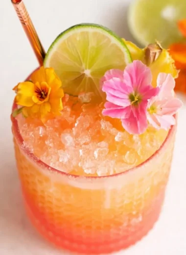 Vibrant Pineapple Mango Rum Punch in a decorative glass with tropical fruits.