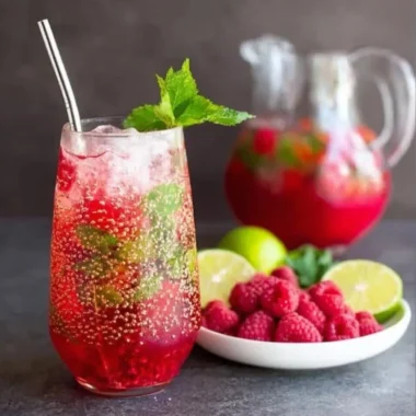 Delicious Raspberry Mojito cocktail garnished with fresh raspberries and mint