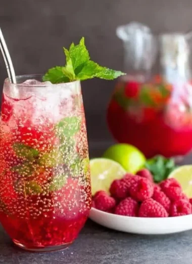 Delicious Raspberry Mojito cocktail garnished with fresh raspberries and mint