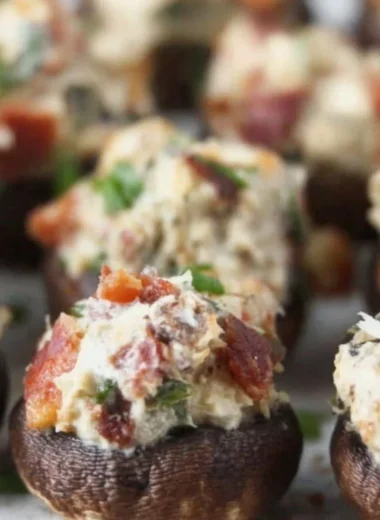 Stuffed mushrooms with bacon, cream cheese, and green onions on a serving platter