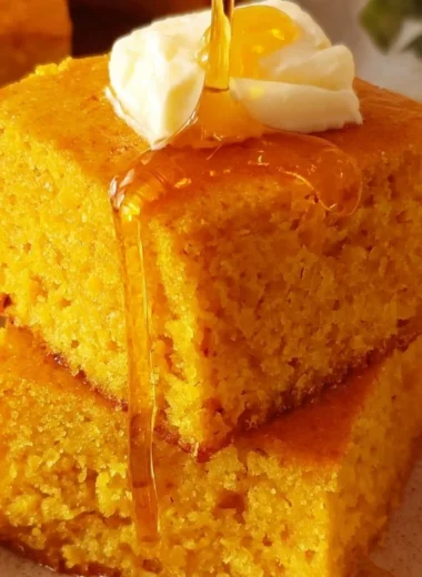 Slice of homemade Sweet Potato Cornbread on a wooden plate.