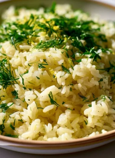 Delicious bowl of authentic Greek lemon rice garnished with fresh herbs