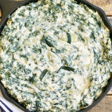 Cozy creamy spinach artichoke dip served in a bowl with crackers