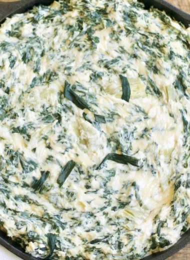 Cozy creamy spinach artichoke dip served in a bowl with crackers