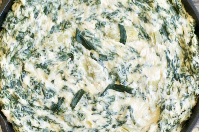 Cozy creamy spinach artichoke dip served in a bowl with crackers
