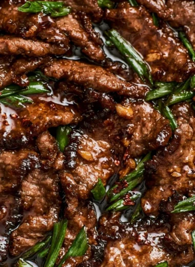 Delicious easy Mongolian beef served on a plate with green onions and rice