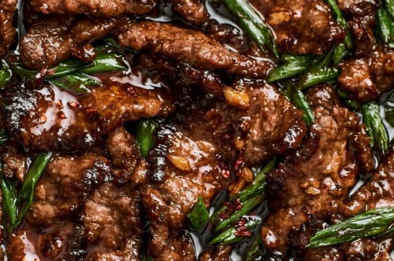 Delicious easy Mongolian beef served on a plate with green onions and rice