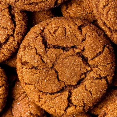 Freshly baked chewy gingersnap cookies on a cooling rack.