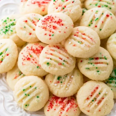 Homemade whipped shortbread cookies on a rustic wooden table.